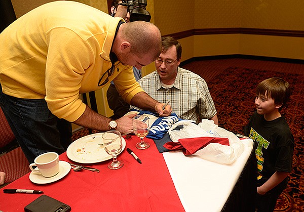 STAFF PHOTO ANTHONY REYES 
Clint Robinson, former Northwest Arkansas Naturals player and Triple Crown winner, signs autographs Monday for Byron Garibaldi, from left, and Kyle Garibaldi, 12, after the Springdale Rotary meeting and Hot Stove luncheon featuring past and present Naturals players at the Holiday Inn in Springdale.