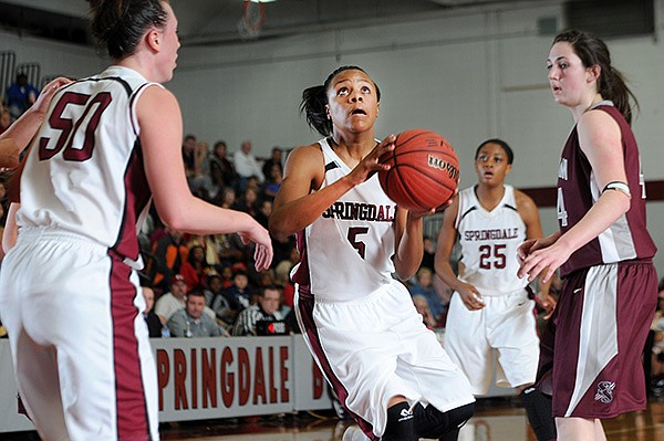 STAFF PHOTO SAMANTHA BAKER 
• @NWASAMANTHA 
Kierra Lang, center, of Springdale High drives up the middle Friday against Siloam Springs at Bulldog Gym in Springdale. Lang is the 7A/6A-West Girls Player of the Week.