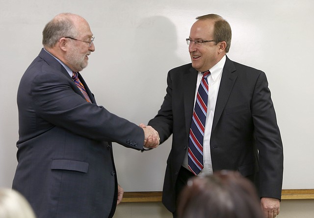 Jeff Jeffus, left, president of WEHCO Newspapers, congratulates Todd Nelson, right, following his introduction as the new president of Northwest Arkansas Newspapers and vice president and general manager of the Northwest Edition of the Arkansas Democrat-Gazette Tuesday morning at The Northwest Arkansas Times office building in Fayetteville.