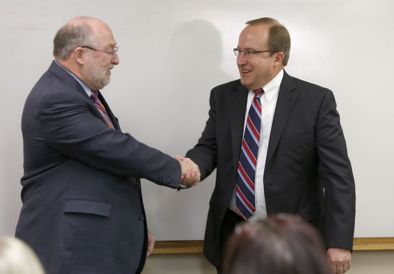 Jeff Jeffus, left, president of WEHCO Newspapers, congratulates Todd Nelson, right, following his introduction as the new president of Northwest Arkansas Newspapers and vice president and general manager of the Northwest Edition of the Arkansas Democrat-Gazette Tuesday morning at The Northwest Arkansas Times office building in Fayetteville.