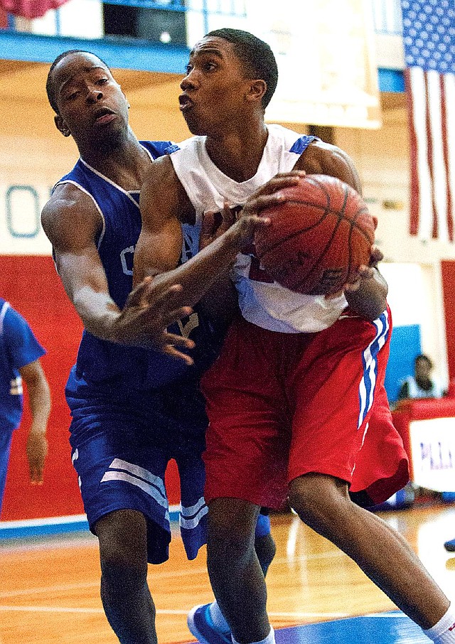 Little Rock Parkview’s Javon Franklin (front) drives to the basket against Conway’s Tyler Smith during the Patriots’ 66-31 victory over the Wampus Cats on Tuesday in Little Rock. 