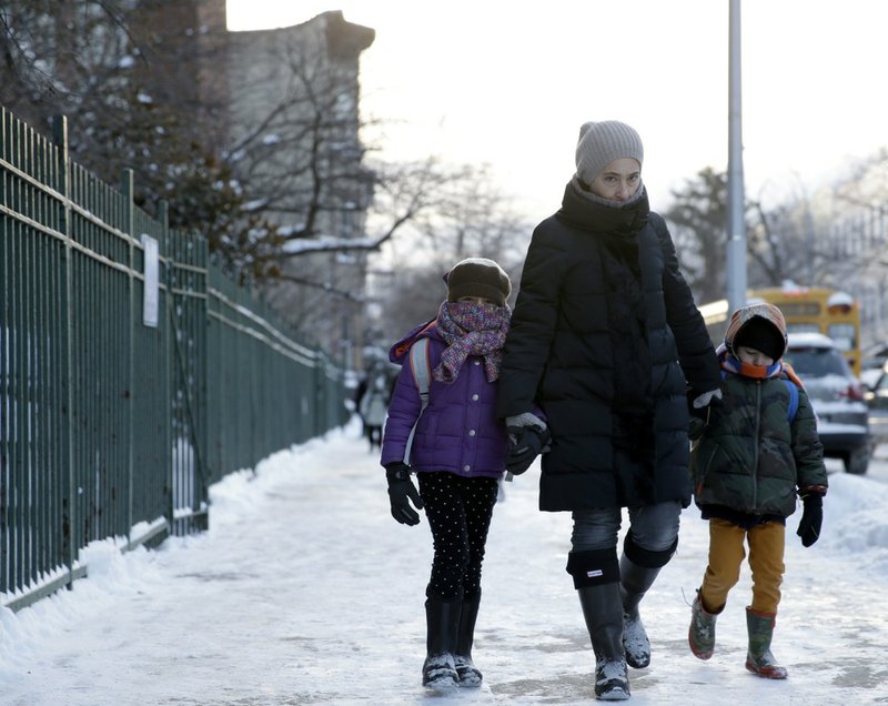 Parents and children arrive to school bundled up against the cold in the Brooklyn borough of New York on Wednesday, Jan. 22, 2014. A winter storm stretched from Kentucky to New England and hit hardest along the heavily populated Interstate 95 corridor between Philadelphia and Boston. 