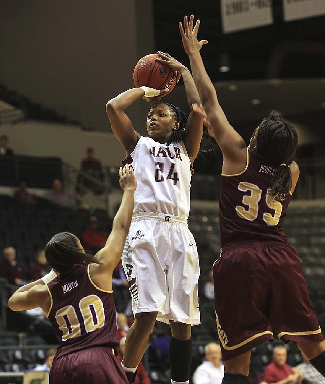 UALR guard Taylor Gault shoots over Texas State defenders Kaylan Martin (left) and Erin Peoples (right) during Wednesday night’s game at the Jack Stephens Center in Little Rock. Gault finished with a game-high 23 points in the Trojans’ 77-70 victory. 