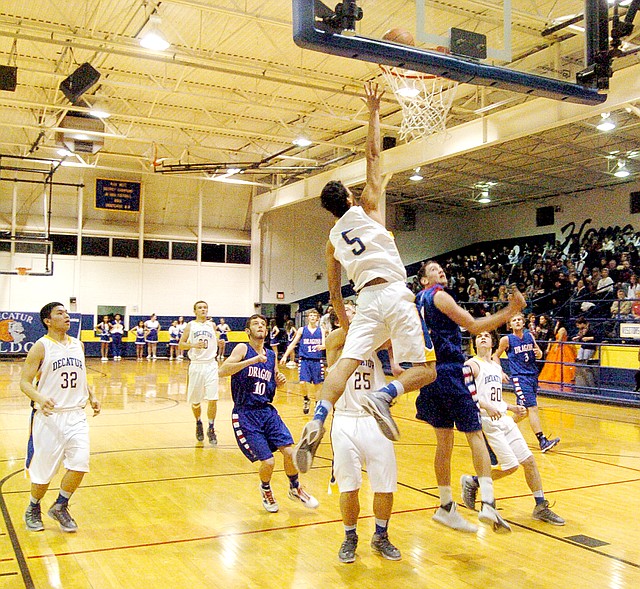 Photo by Mike Eckels Varsity guard/forward, Mario Urquidi (#5), reaches over the rim for another layup during the Decatur colors day homecoming game with the Mountainburg Dragons on Jan. 14 at the Lloyd Peterson Gym. Urquidi is credited with a double-double (when a player reaches over 10 in two categories) against Mountainburg, getting 27 points and 21 rebounds.