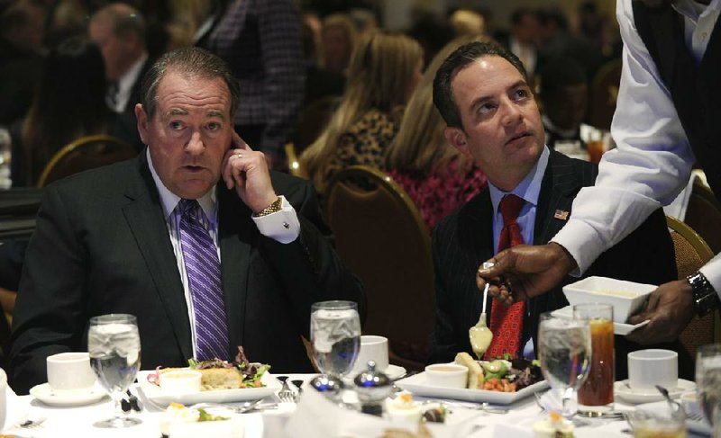 Former Arkansas Gov. Mike Huckabee, left, sits next to Republican National Committee (RNC) Chairman Reince Priebus, right, before Huckabee spoke at the Republican National Committee winter meeting in Washington, Thursday, Jan. 23, 2014. (AP Photo/Susan Walsh)