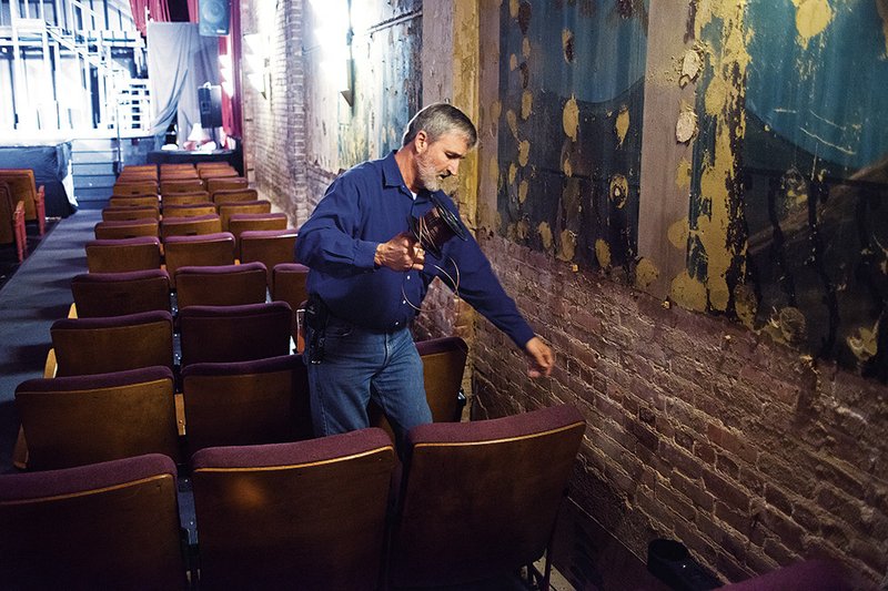 Fred Anderson of Saline Audiology unrolls wire to install as part of the hearing-loop system at the Royal Theatre in Benton. The system will allow sound from productions to be broadcast to the hearing aids of those in attendance.