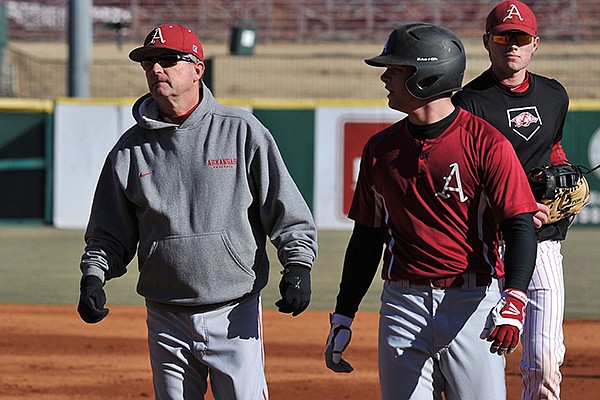 Arkansas coach Dave Van Horn works with the Razorbacks during the first practice of the season Friday afternoon at Baum Stadium in Fayetteville.
