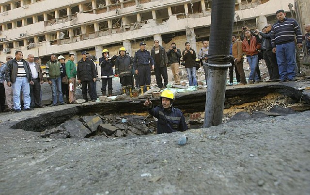 An Egyptian firefighter checks a crater made by a blast at the Egyptian police headquarters in downtown Cairo, Egypt, Friday, Jan. 24, 2014. Three bombings hit high-profile areas around Cairo on Friday, including a suicide car bomber who struck the city's police headquarters, killing several people in the first major attack on the Egyptian capital as insurgents step up a campaign of violence following the ouster of the Islamist president. (AP Photo/Amr Nabil)