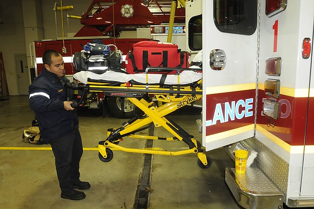 Omar Carrillo, a firefighter and paramedic, inspects a Rogers Fire Department ambulance at the start of his shift on Thursday Jan. 23 2014 at the main fire station downtown.