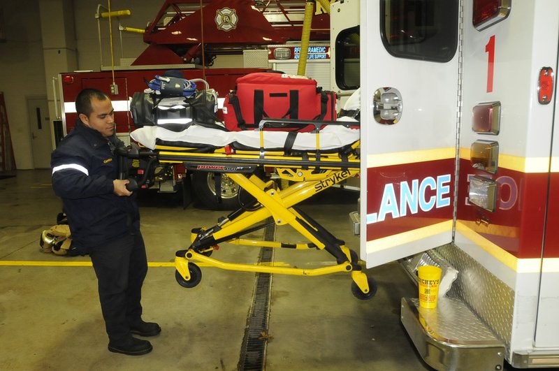 Omar Carrillo, a firefighter and paramedic, inspects a Rogers Fire Department ambulance at the start of his shift on Thursday Jan. 23 2014 at the main fire station downtown.