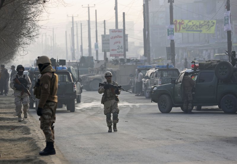 Afghan security personnel walk at the site of a suicide attack in Kabul, Afghanistan, Sunday, Jan. 26, 2014. An Afghan official said a suicide bomber attacked a military bus in Kabul, killing at least four people. (AP Photo/Massoud Hossaini)
