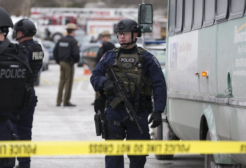 A heavily armed police officer walks on scene after a shooting at The Mall in Columbia on Saturday, Jan. 25, 2014 in Columbia, Md. Police say three people died in a shooting at the mall in suburban Baltimore, including the presumed gunman. (AP Photo/ Evan Vucci)