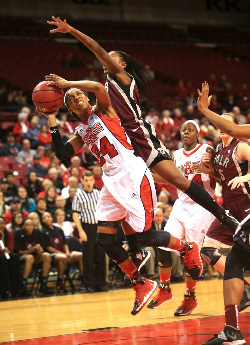 Arkansas State guard Aundrea Gamble (24) is fouled on her way to the basket by UALR guard Taylor Gault during Saturday’s game at the ASU Convocation Center in Jonesboro. Gamble finished with 27 points as the Red Wolves beat the Trojans 77-45. 