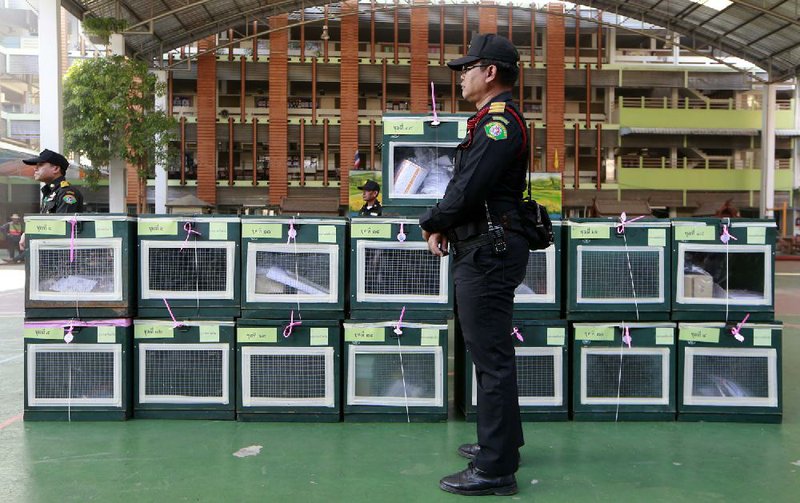 Bangkok Metropolitan officials guard ballot boxes before placing them at polling stations during an advance voting in Bangkok, Thailand, Sunday, Jan. 26, 2014. Anti-government demonstrators trying to derail a contentious general election scheduled next week in the country swarmed dozens of polling stations Sunday, chaining doors and gates shut and blocking hundreds of thousands of voters from casting advance ballots in the latest blow to the country's increasingly embattled government. (AP Photo/Wason Wanichakorn)