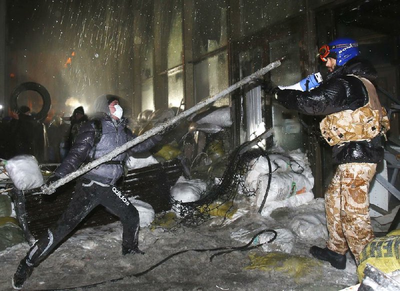Protesters attack the Ukrainian House government building in central Kiev early today. 