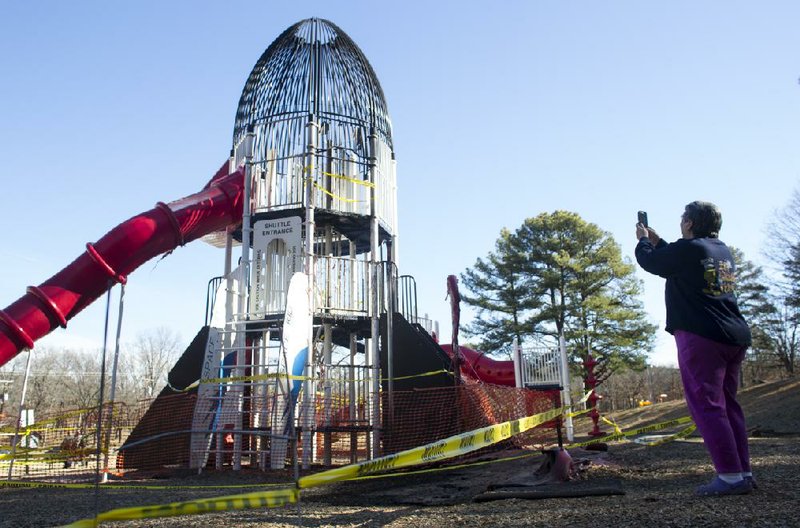 
Arkansas Democrat-Gazette/MELISSA SUE GERRITS 01/25/2014- Pattie Platt, a 50 year resident of North Little Rock, takes a photo of the rocket slide at Burns park that was vandalized over night January 25, 2014. Platt says she plans to post photos to a Facebook page in hopes of raising money for a rebuild. "So many memories here", Platt said, "My ex husband was one of the first kids to slide down the original." The slide that melted to the ground was from a revamp 8 years ago. 