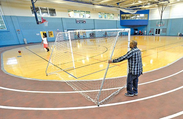STAFF PHOTO ANTHONY REYES 
Desmond Johnson of Springdale moves a futsol goal Friday in The Jones Center gymnasium in Springdale. Johnson was waiting to play basketball with a friend while a group finished a game of futsol, a type of indoor soccer. The Jones Center is looking to upgrade exterior basketball facilities since use indoors is exceeding the space available.