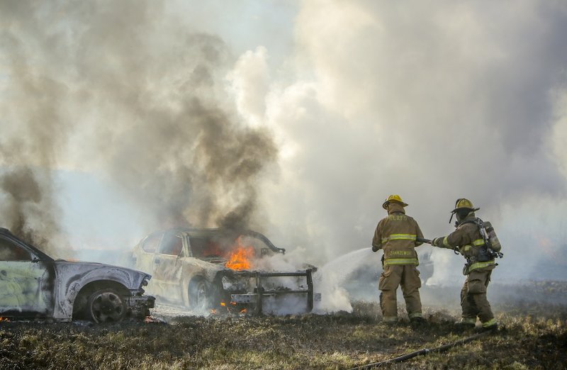 North Little Rock firefighters put out remaining flames inside two police cars that burned to the ground, along with the truck that the officers pursued, in a field behind Alliance Parts Warehouse at 600 Fiber Optic Dr. in North Little Rock on Monday afternoon. The driver of the truck led police from multiple jurisdictions on a chase that started in Grant County and ended with the suspect running on foot. Heat from the vehicles on the dry grass in the field purportedly started the fire, which spread over 10-20 acres before being contained.