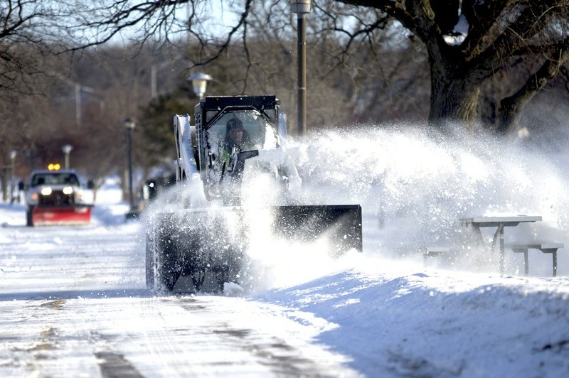 Rockford Park District employee Taylor Hennelly operates a Bobcat equipped with a snowblower Monday, Jan. 27, 2014, along the Rock River Recreation Path in Rockford, Ill. A second deep freeze in weeks locked the Midwest in its icy grip Monday, bringing with it wind chills ranging from the negative teens to 40s.