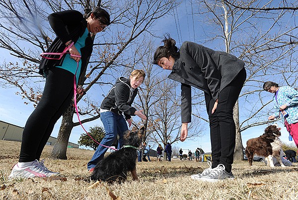 Amanda Henry, center, a dog trainer with Dogtastic Training, helps Lyanne Centeno, right, and her sister, Magaly Centeno, both of Fayetteville, as they work Saturday with their dog, Yeti, during a free dog training clinic at the Fayetteville Animal Shelter.
STAFF PHOTO ANDY SHUPE
