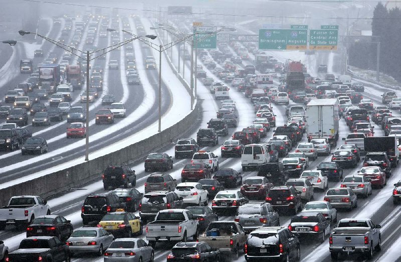 Traffic inches along the connector of Interstates 75 and 85 as snow blankets Atlanta on Tuesday. The winter storm caused Georgia alligators to burrow into the mud for warmth, closed the Lake Ponchartrain Causeway in Louisiana and left icicles on palm trees in Gulf Shores, Ala. 
