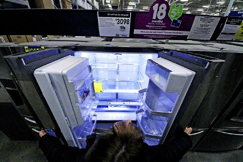 A shopper looks at a General Electric refrigerator at a Lowe’s store in Cranberry Township, Pa., on Jan. 16. Orders for durable goods such as refrigerators fell 4.3 percent in December, the Commerce Department reported Tuesday. 