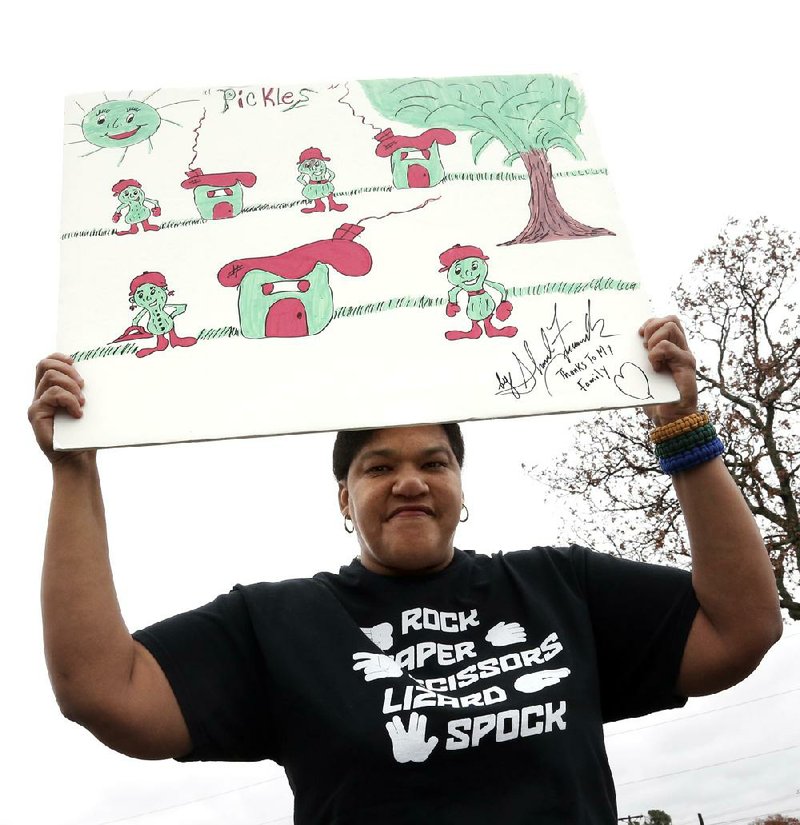 Sharrol Frederick holds up an illustration of the pickle characters she has included in the first two of a planned series of children’s books. Frederick says she has more than 1,000 pickle characters she’s developed over the course of several decades. 