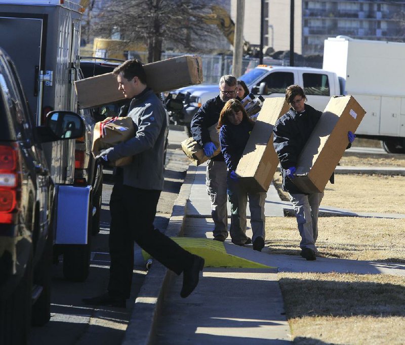 Officials with the FBI carry boxes out of Rogers Photo Archive in North Little Rock on Tuesday afternoon. 