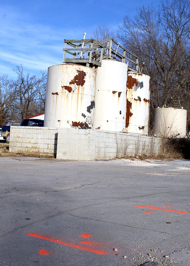 Photo by Dodie Evans Red paint marks the location of a sewer line that will be replaced. A leaking tank, in the background, contaminated the line.