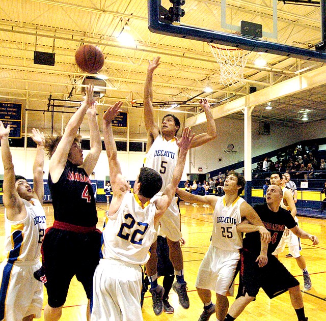 Photo by Mike Eckels A pack of bulldogs surrounds a rattler as he tries for a bucket. Decatur s Pheng Lee (#21, far left) positions himself behind the shooter while Trey Kell (# 22) and Victor Urquidi (#25) prevent the player from getting a closer shot. Mario Urquidi (#5) goes up for a block. Meng Vang (#32, far right) takes up position for a rebound off of rim. This team effort was part of the Jan. 20 game with the Magazine Rattlers at home. Decatur defeated Magazine, 51 to 20.