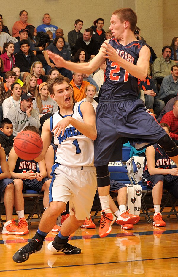 STAFF PHOTO MICHAEL WOODS 
Hunter Hill, Rogers High guard, is fouled Tuesday by Rogers Heritage defender Crist Olsen at King Arena in Rogers.