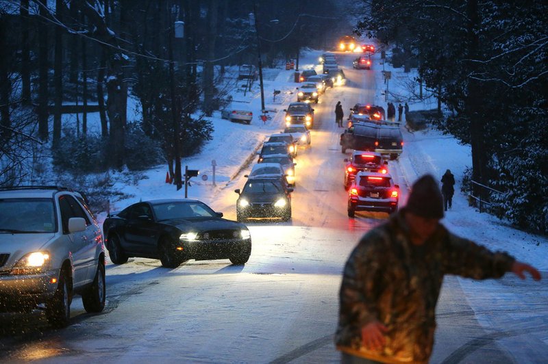 Dozens of drivers become stranded on Womack Road as dropping temperatures turn the hill into a sheet of ice on Tuesday night, Jan. 28, 2014, in Dunwoody, Ga. 