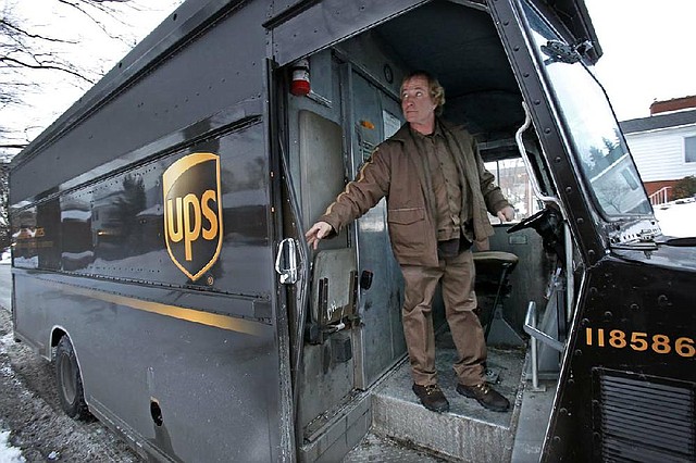 In this Tuesday, Jan. 28, 2014 photo, a UPS driver returns to his truck after making a delivery in Mt. Lebanon, Pa. UPS reports quarterly earnings on Thursday, Jan. 30, 2014. (AP Photo/Gene J. Puskar)