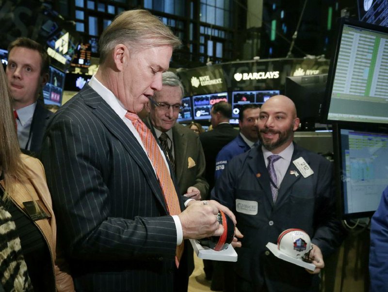 Denver Broncos Executive VP of Football Operations John Elway signs an autograph for a trader on the floor of the New York Stock Exchange, before opening bell ceremonies, Thursday, Jan. 30, 2014. (AP Photo)