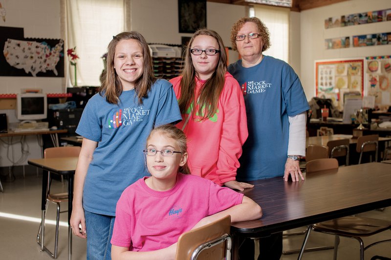 Standing, Kyndal Dollar, left, and Makayla Barnhill, center; and Jenna Sablotny, seated, placed second in the Stock Market Game for Region 4 under guidance from their teacher, Dee Gaskins, right.