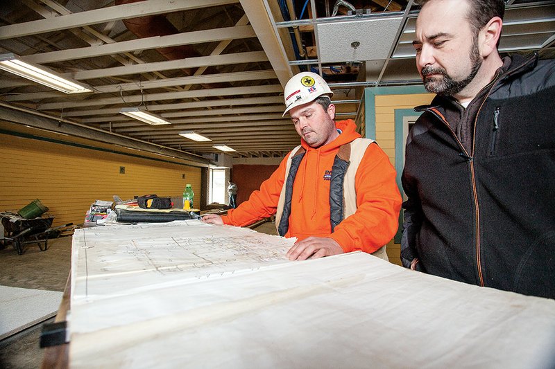 Scotty Loyd, left, job superintendent for Dayco Construction Inc. of Damascus, and Zac Cothren, director of the Cleburne County Library in Heber Springs, look over the plans for remodeling and expanding the building. The $2.2 million project, scheduled to be completed in March, will more than double the facility’s space. The library will become the Mary Wold County Library.