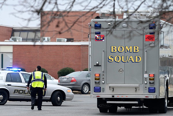 A Springdale Police Officer leads the Bentonville Bomb Squad into a parking lot Friday, Jan. 31, 2014 at Southwest Junior High School in Springdale. A bomb threat was issued at the school. After a search no suspicious packages were located and students were let back into the building.