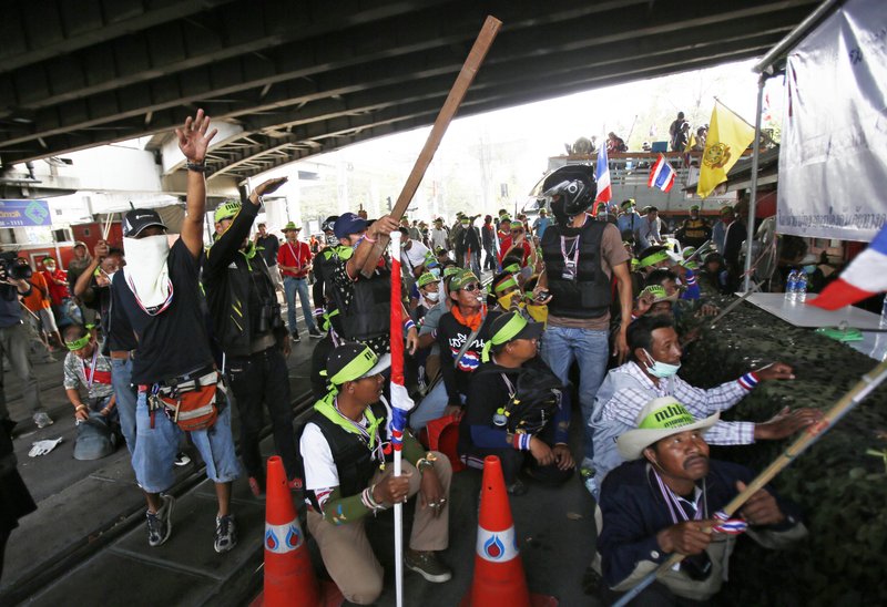 Anti-government protesters try to antagonize government supporters during a gun fight Bangkok, Thailand, Saturday, Feb. 1, 2014. Gunfire rang out at a major intersection in Thailand's capital on Saturday as clashes between protesters and government supporters erupted on the eve of tense nationwide elections. At least seven people are reported wounded, including an American photojournalist. (AP Photo/Wally Santana)