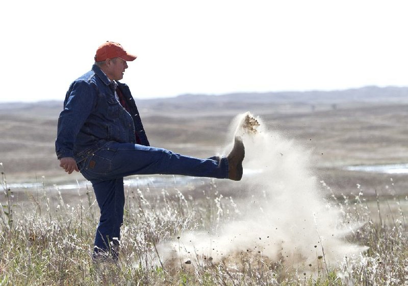 Bruce Boettcher, a rancher in Bassett, Neb., kicks up sand in his pasture to demonstrate the fragility of the Nebraska Sandhills near the Keystone pipeline planned route. “We’re not going to stand still on this,” Boettcher said Friday. 