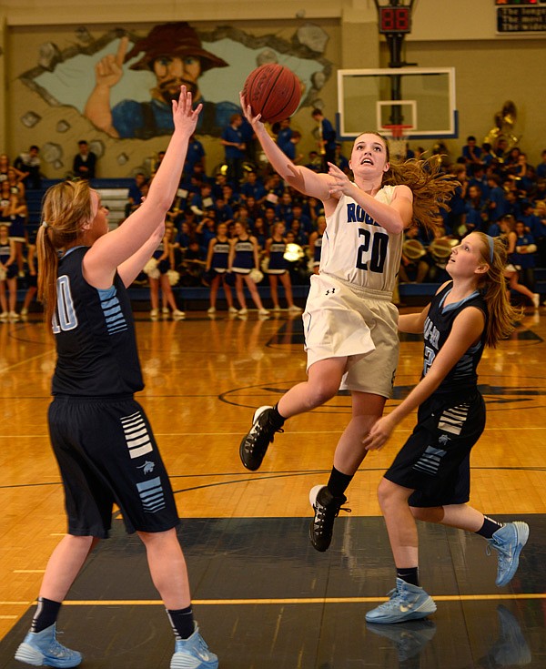 Callie King (20) Rogers junior, shoots as Bailey Schalk (10) Springdale Har-Ber junior and Anna Chancellor (12) Springdale Har-Ber  junior defend Friday, Jan. 31, 2014 at Rogers.