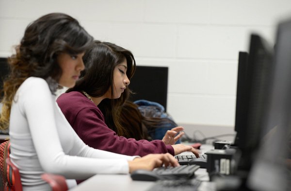 Jeffifer Nava, right, and Anita Andrade, both ninth grade students at George Junior High School on computers Thursday Jan. 30 2014 at the school in Springdale. The Springdale School District is using a large amount of money from the Race To The Top grant received in December to purchase technology, specifically to put a computer or tablet in the hands of every student in the district.