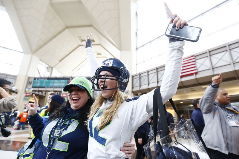 Football fans cheer at the Secaucus Junction, Sunday, Feb. 2, 2014, in Secaucus, N.J. The Seattle Seahawks are scheduled to play the Denver Broncos in the NFL Super Bowl XLVIII football game on Sunday evening at MetLife Stadium in East Rutherford, N.J. (AP Photo/Matt Rourke)