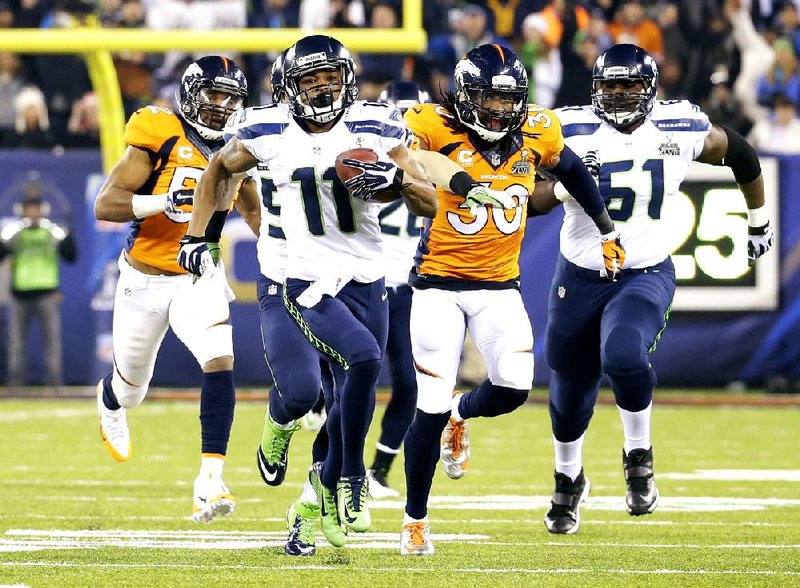 Seattle Seahawks' Percy Harvin (11) runs from Denver Broncos' David Bruton (30) while returning a kickoff 87-yards for a touchdown during the second half of the NFL Super Bowl XLVIII football game Sunday, Feb. 2, 2014, in East Rutherford, N.J.  (AP Photo/Ted S. Warren)