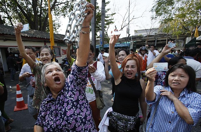 Voters hold their identification cards and the chains that held the gate of the polling station closed, as they demand the right to vote during general elections in Bangkok, Thailand, Sunday, Feb. 2, 2014. Around the country, the vast majority of voting stations were open and polling proceeded relatively peacefully, but the risk of violence remained high a day after gun battles in Bangkok left seven people wounded. (AP Photo/Wally Santana)