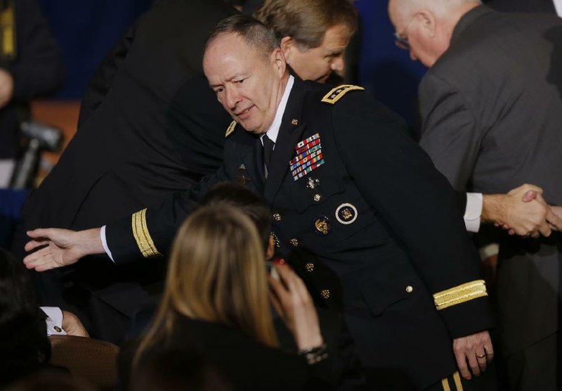 National Security Agency Director Gen. Keith Alexander greets audience members before President Barack Obama spoke about National Security Agency (NSA) surveillance, Friday, Jan. 17, 2014, at the Justice Department in Washington. Seeking to calm a furor over U.S. surveillance, President Barack Obama on Friday called for ending the government's control of phone data from hundreds of millions of Americans and immediately ordered intelligence agencies to get a secretive court's permission before accessing such records. (AP Photo/Charles Dharapak)