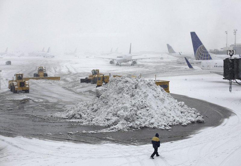 Plows clear runways as snow falls at Newark Liberty International Airport Monday, Feb. 3, 2014, in Newark, N.J. Air traffic is disrupted in Ohio, the Mid-Atlantic and the Northeast as another winter storm bears down on the eastern U.S., only a day after temperatures soared into the 50s. 