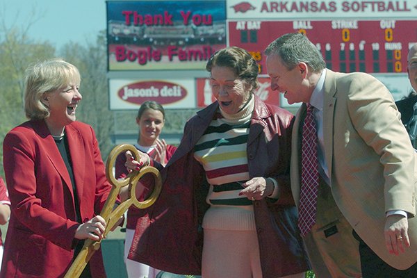 Associate Vice Chancellor and Executive Associate AD, hands a pair of giant scissors to Marilyn Bogle (center) as Jeff Long (right) Vice Chancellor and Director of Athletics, help cut the ribbon during the official dedication of Bogle Park on April 11, 2009.