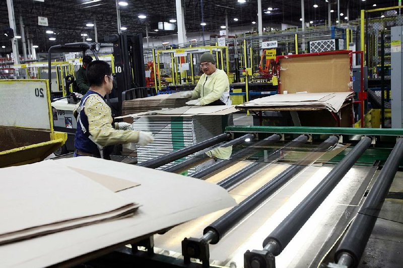 Two workers prepare custom glazed glass for shipping at the Tru Vue facility in McCook, Illinois, U.S., on Thursday, Jan. 30, 2014. The Institute of Supply Management is expected to release monthly U.S. manufacturing data on Feb. 3. Photographer: Tim Boyle/Bloomberg