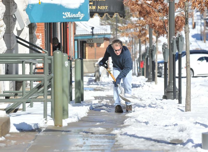 NWA Media/Michael Woods --02/03/2014--  
David Adams with David Adams Fine Jewelry in Fayetteville works on clearing the snow from the sidewalk in front of his building on the Fayetteville square Monday morning.  A snow storm dropped several inches of snow across Northwest Arkansas.