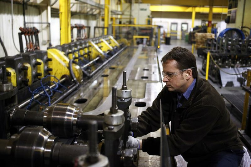 Ronnie Poynter adjusts a roll mill, used to manufacture metal components for office cubicles and furniture at the Roll Forming Corp. plant in Shelbyville, Ky., last month. Orders to U.S. factories fell 1.5 percent in December, the Commerce Department reported Tuesday. 